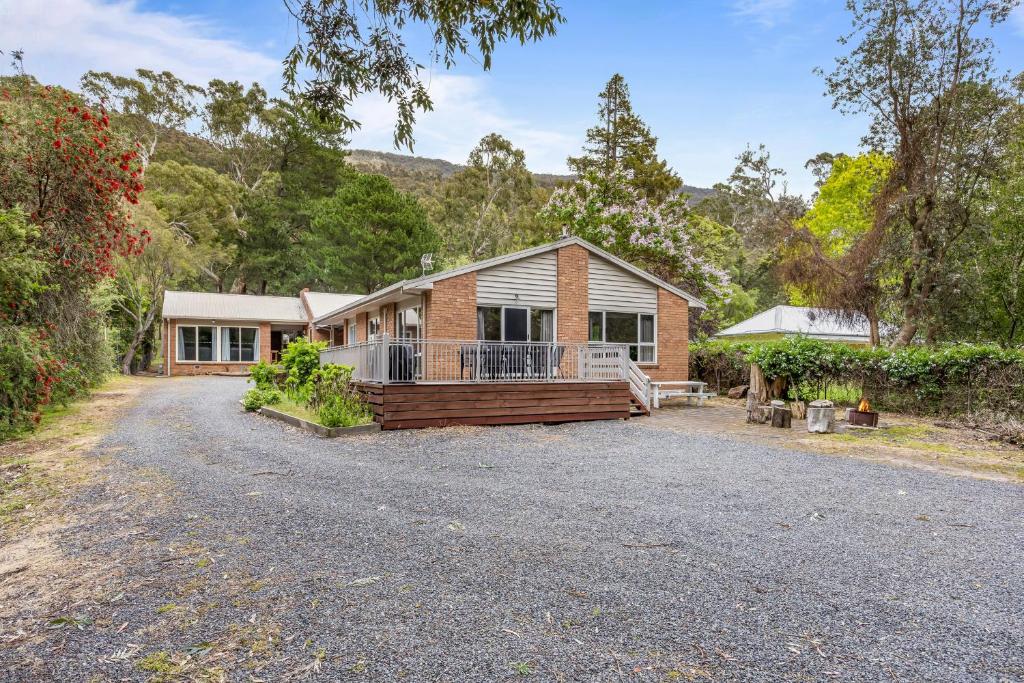 a brick house with a porch on a driveway at Kookaburra Retreat in Halls Gap