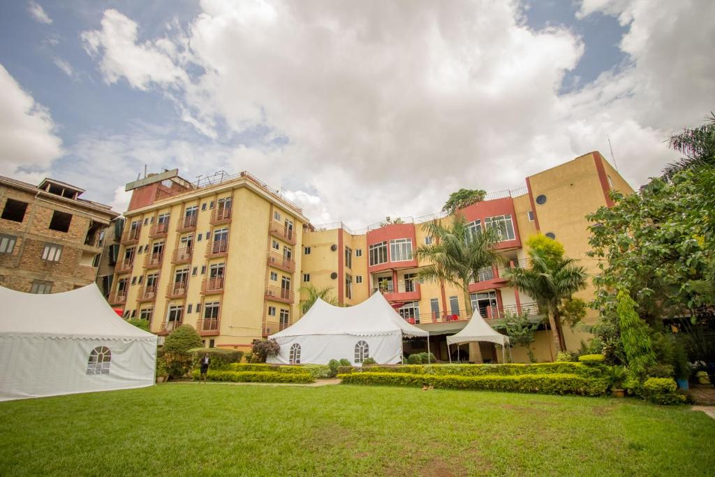 a large building with a lawn in front of it at Grand Global Hotel in Kampala