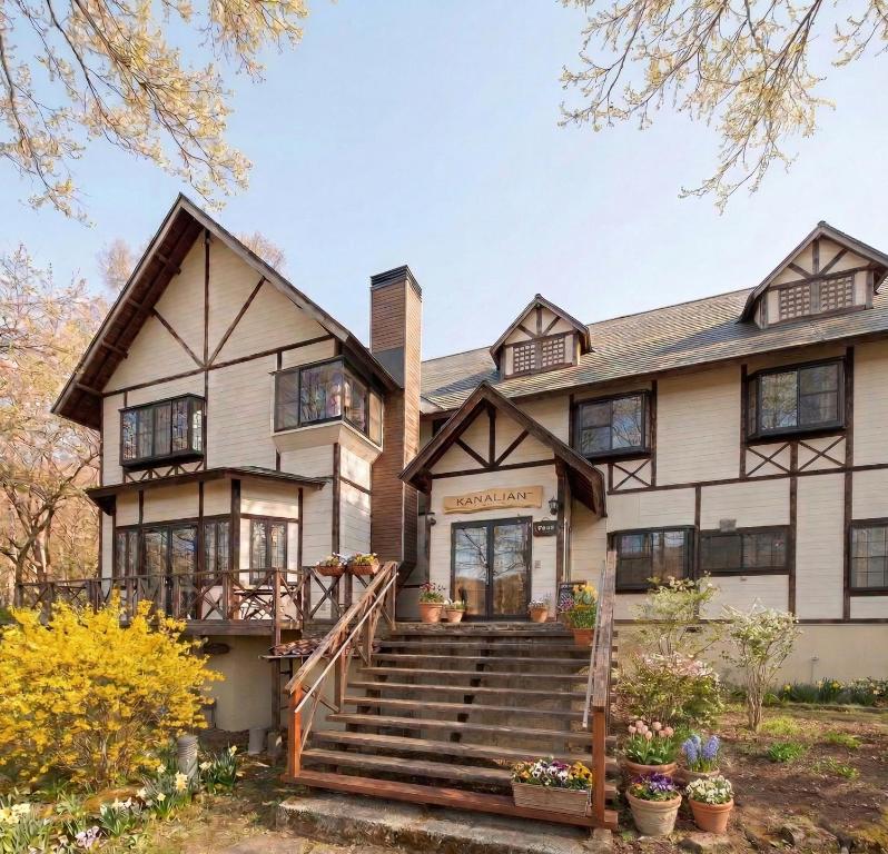 an exterior view of a large house with stairs at カナリアンホテル in Tateshina