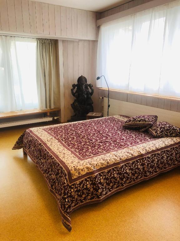 a large bed in a room with windows at Buddha-Loft in Solothurn