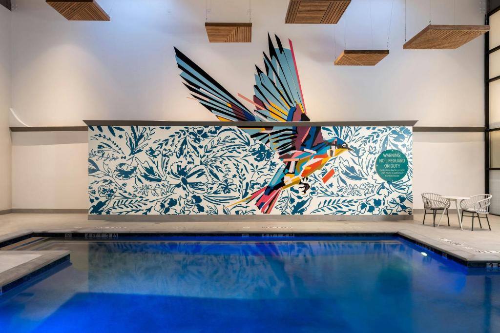 a pool with a mural of a bird on the wall at Hotel Mockingbird, Dallas, a Tribute Portfolio Hotel in Dallas