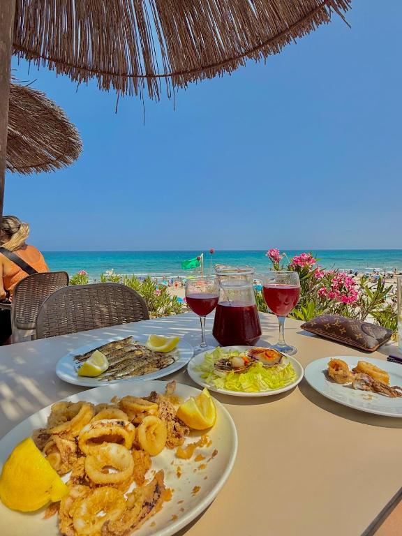 a table with plates of food and drinks on the beach at Mar y Golf in Orihuela Costa