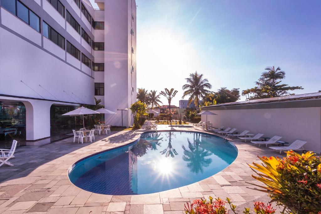 a swimming pool in the middle of a building at Hotel Aojesp in Caraguatatuba