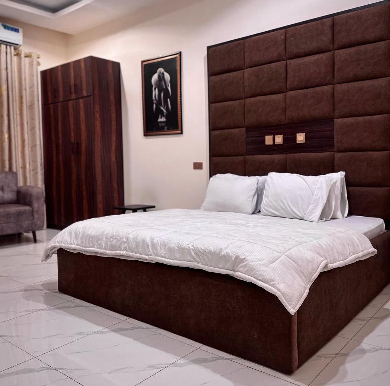 a bedroom with a large bed with a large headboard at Enseno Hotel in Karshi