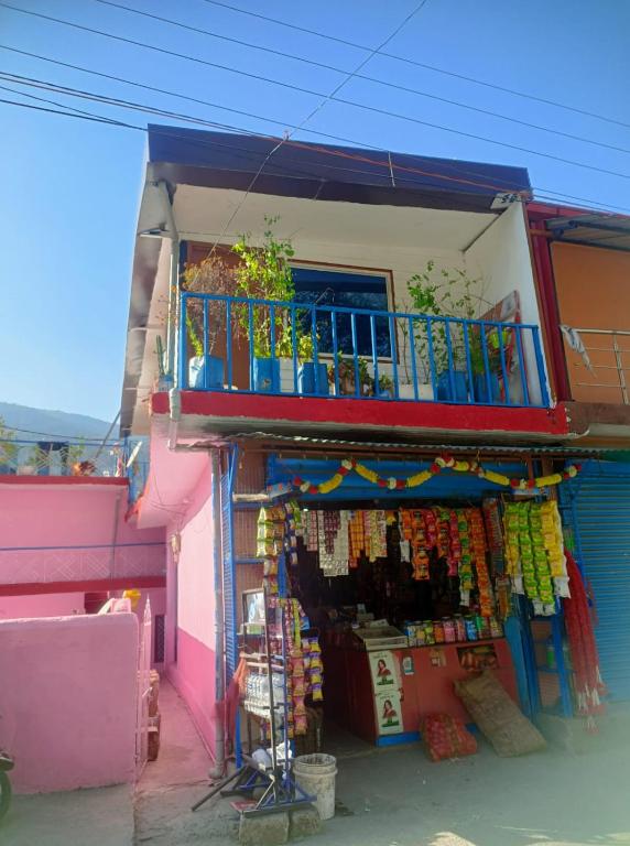 a colorful building with a balcony and a store at The Devine homestay in Ukhimath