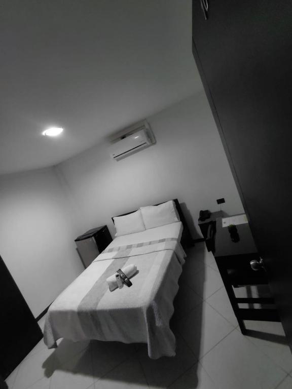 a white room with a bed and a table at Hotel Los Potrillos in Aguazul