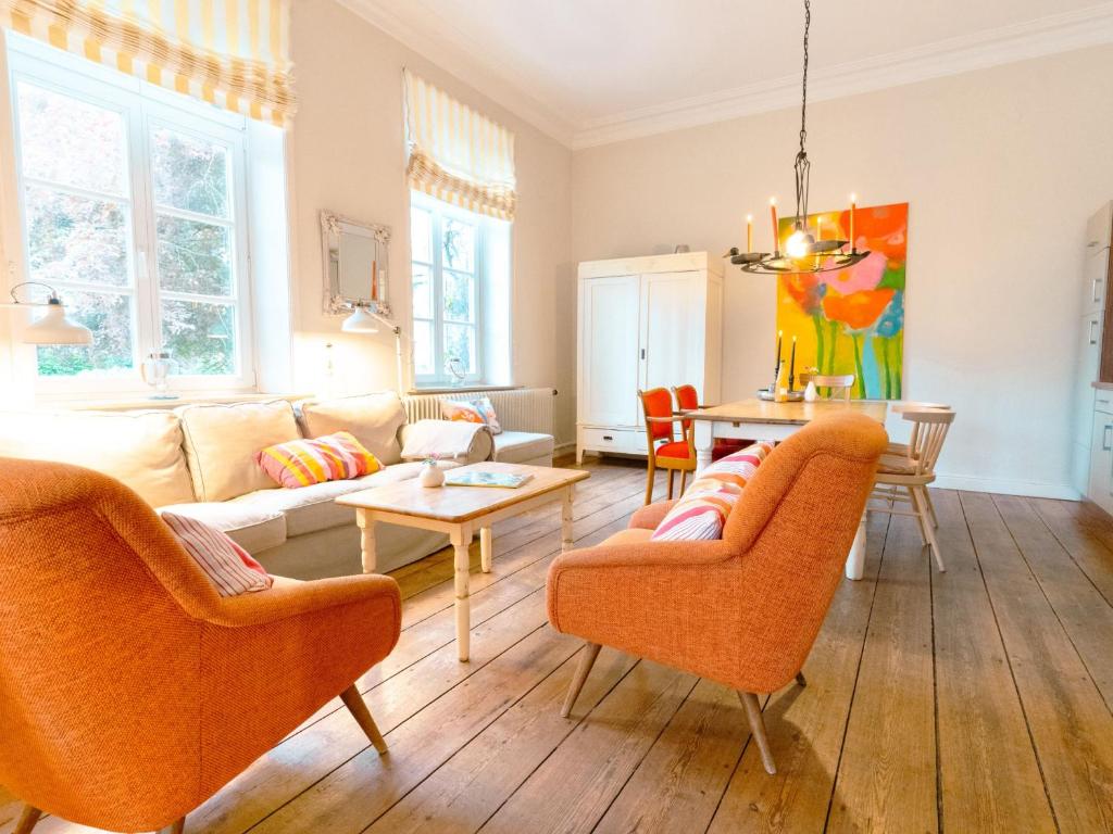 ein Wohnzimmer mit orangefarbenen Stühlen und einem Tisch in der Unterkunft Ostseeferien Evershof in Travemünde