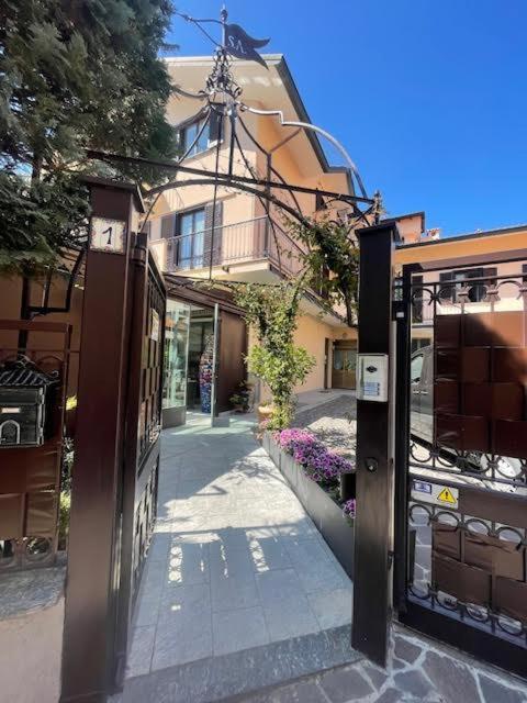 a building with an entrance to a street with flowers at Tommy&Gio in Tradate