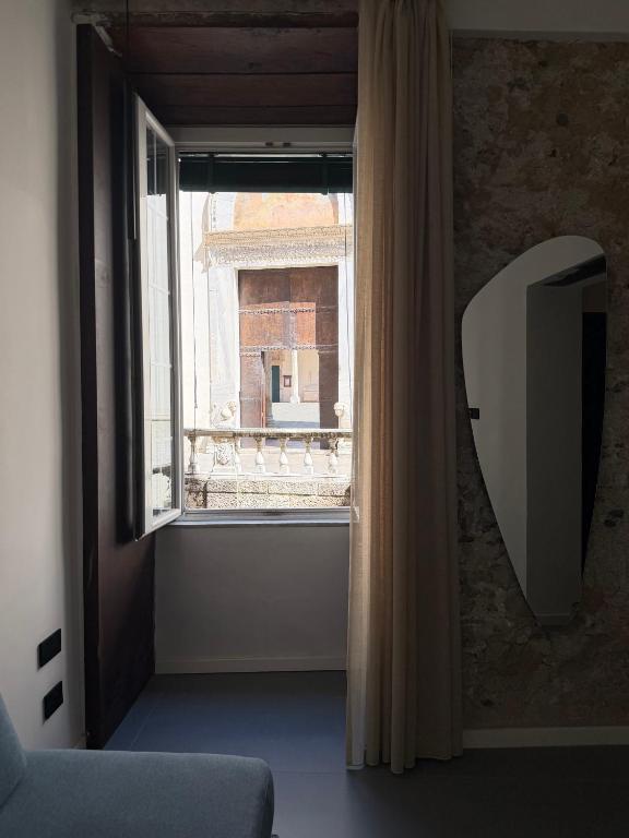 a room with a window with a couch and a television at Dimora Rhea in Salerno