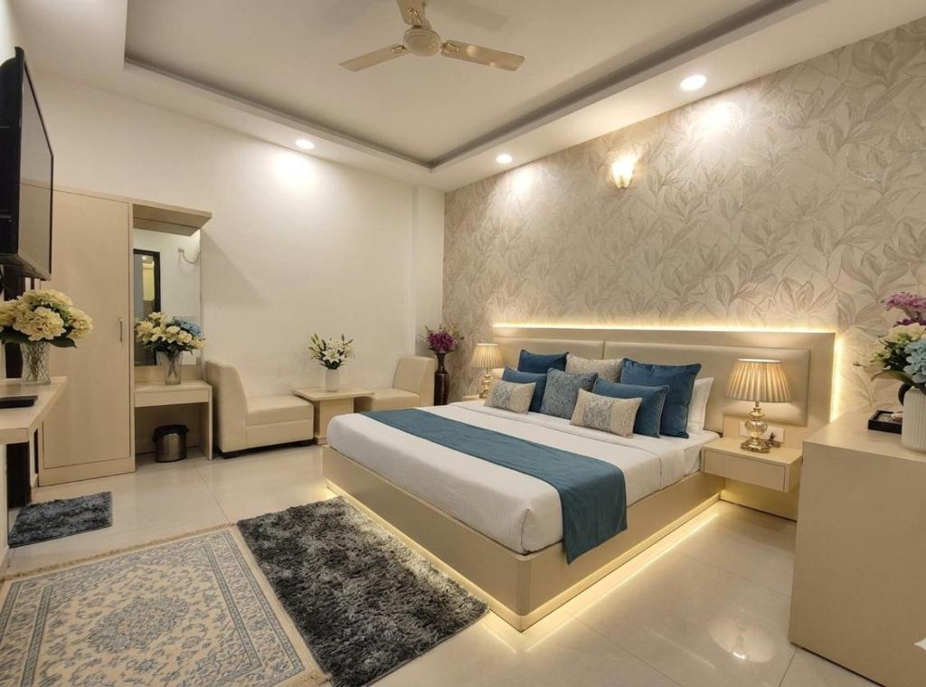 a bedroom with a large bed with blue pillows at Hotel Olive Aero Suites Near Delhi IGI Airport in New Delhi