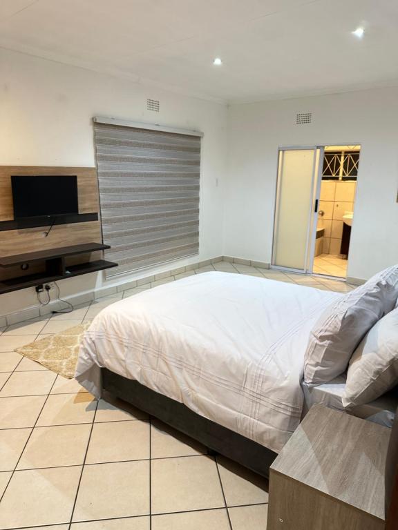 a bedroom with a bed and a flat screen tv at Eagle Empire in Vereeniging