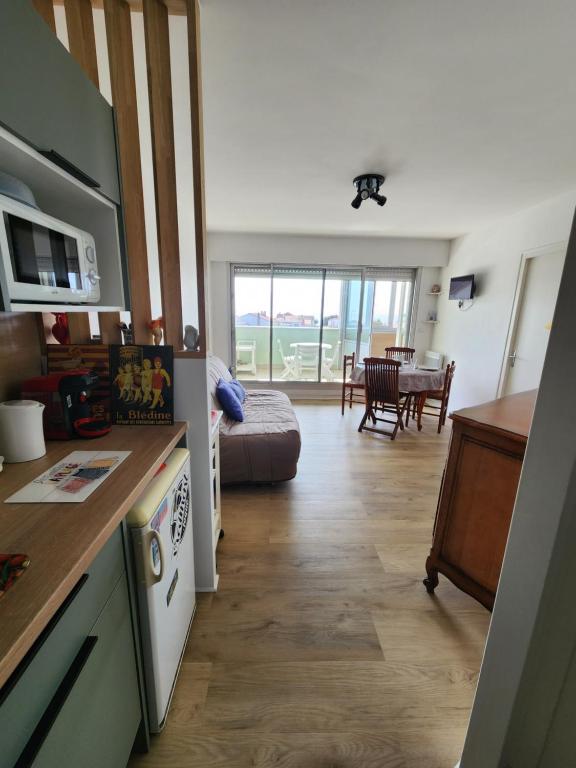 a room with a kitchen and a living room at Les flos bleus in La Bernerie-en-Retz