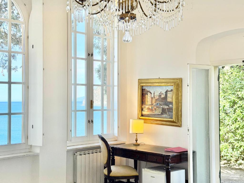 ein Esszimmer mit Schreibtisch und Kronleuchter in der Unterkunft ALBA in Levanto