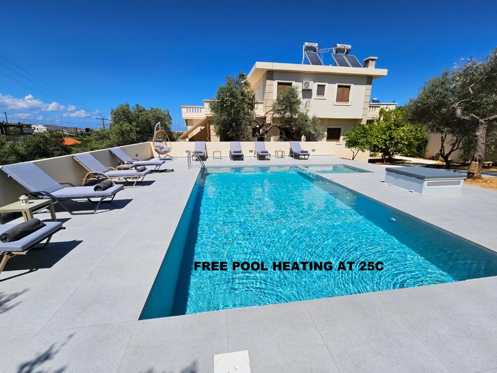 ein Swimmingpool mit Liegestühlen neben einem Haus in der Unterkunft Villa Daratso with private heated pool view to the sea in Daratso