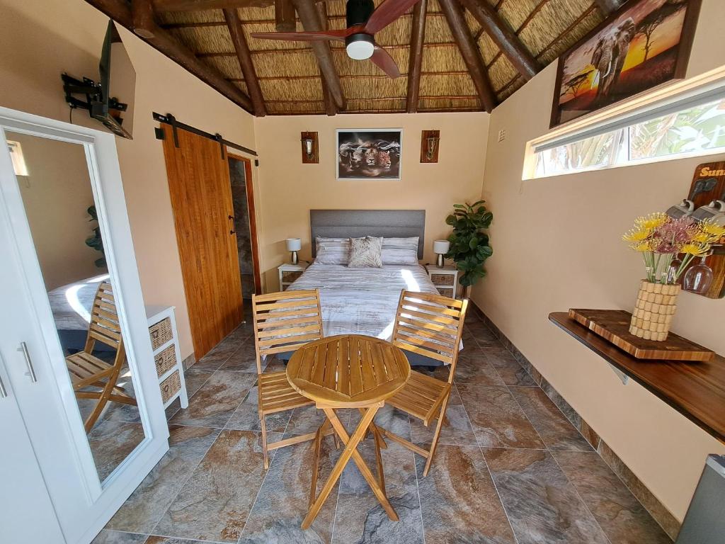 a room with a bed and a table and chairs at Fynbos & Pinot Guest Cottage in Kuilsrivier
