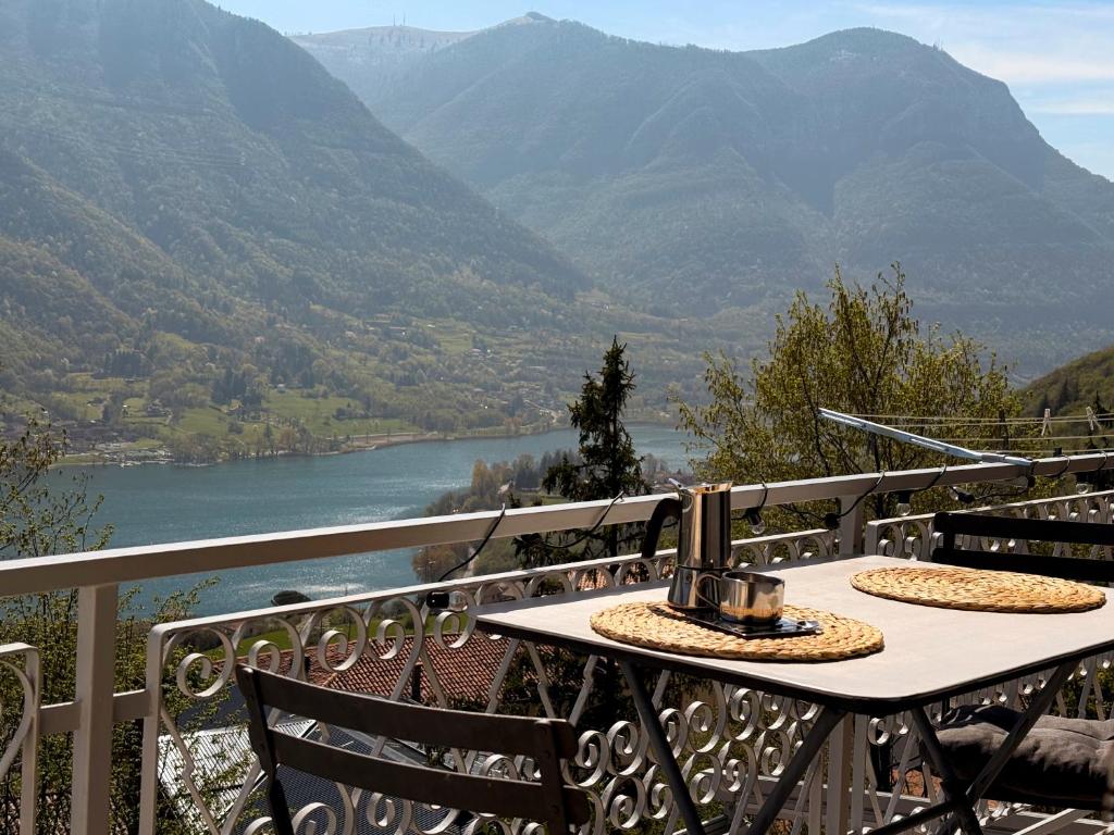 a table on a balcony with a view of a river at Casa Lagò Lagò Panoramic Apartment in Ranzanico