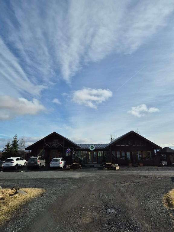 a large building with cars parked in front of it at Guest room with a mountain view in Laugarvatn