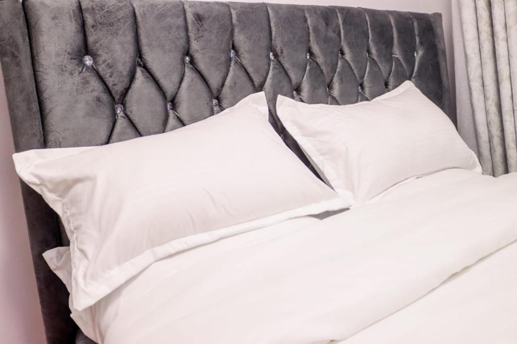 a bed with white pillows on top of it at Maggy Homes in Marimbeti