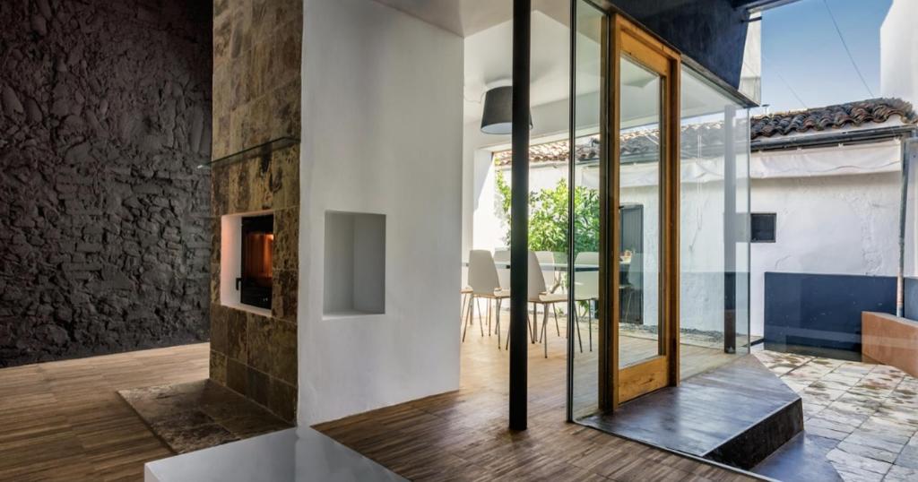 a glass pivot door in a house with a dining room at Fuentes de León in Fuentes de León