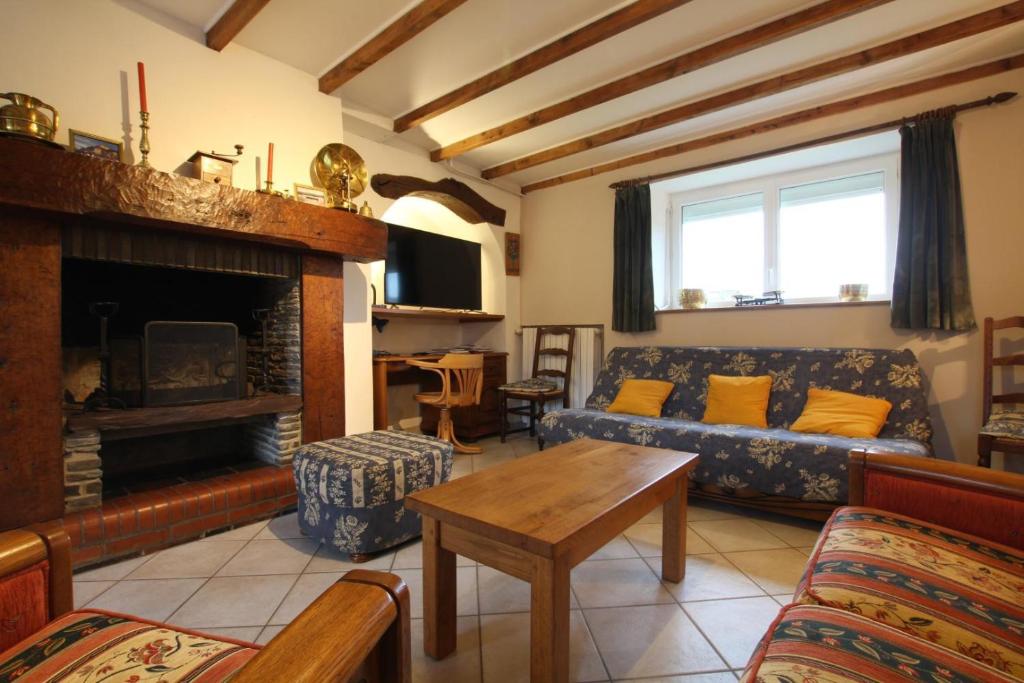 a living room with a couch and a fireplace at Gîte G337 in Quibou