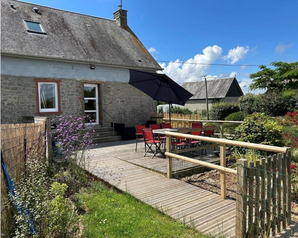 a house with a wooden deck with an umbrella at Gîte G593 in Le Val-Saint-Père