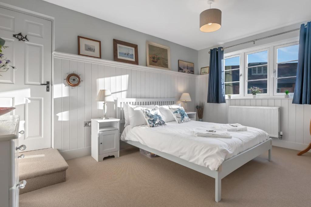 a bedroom with a white bed and blue curtains at Pools Cottages - Warwick Luxury Countryside Near NEC in Kenilworth