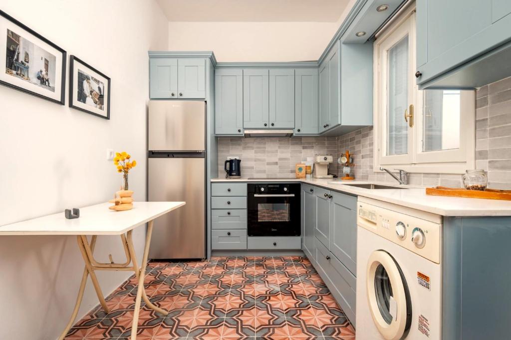 a kitchen with blue cabinets and a washer and dryer at Dafni Local Style, 1 Min from Main Beach in Kardamaina