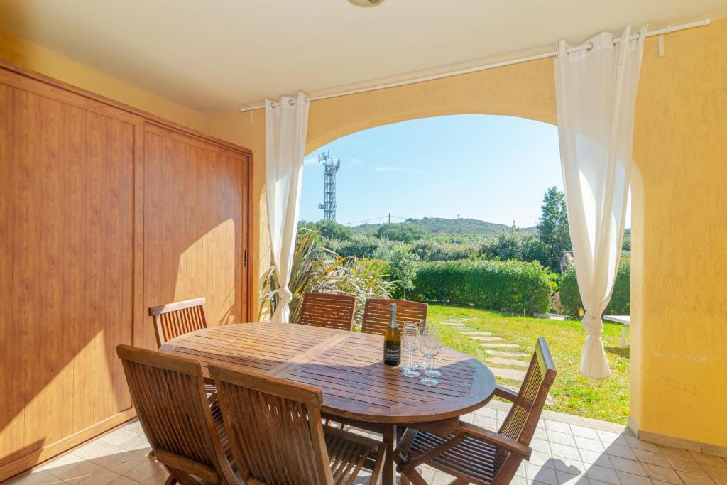 a dining room with a wooden table and chairs at Villetta Giardino e Piscina in Porto San Paolo