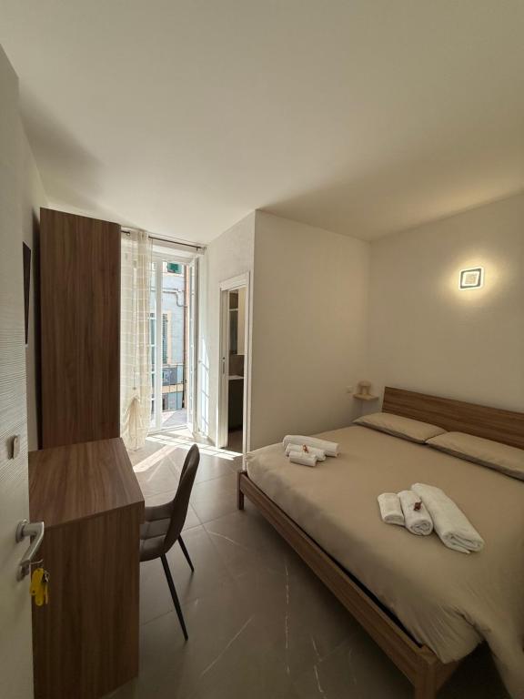 a bedroom with a bed and a chair and a window at Chiara in Cairo Montenotte