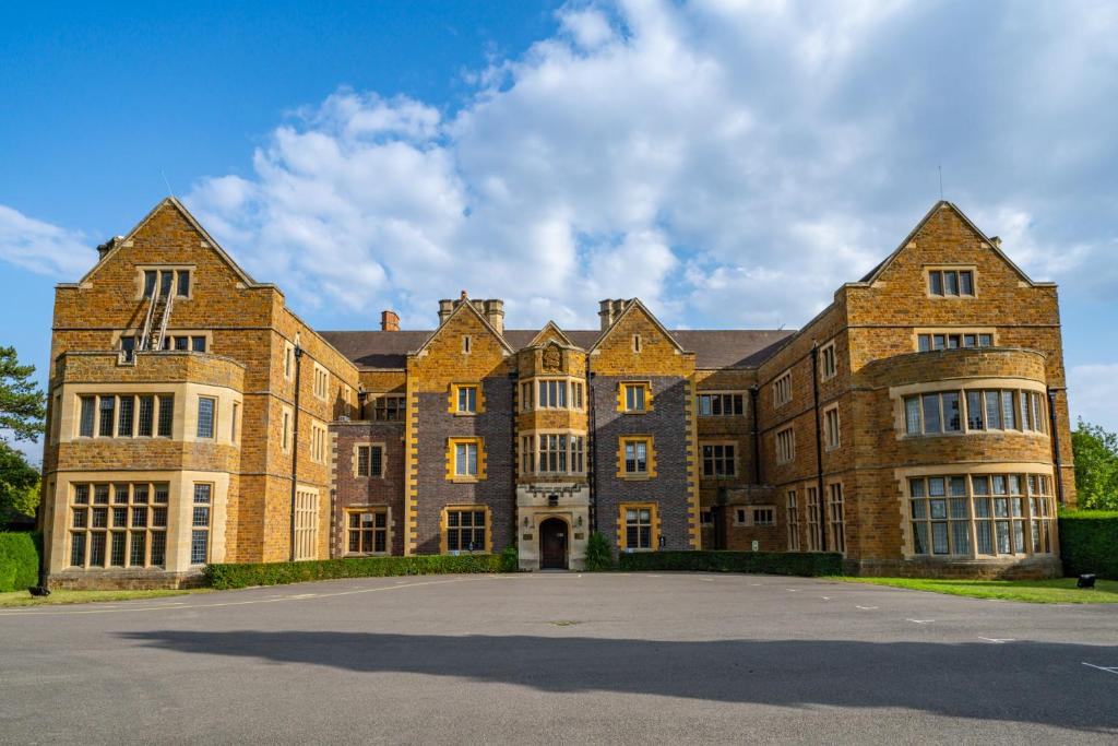 a large brick building with a lot of windows at Ashorne Hill Leamington Spa in Leamington Spa