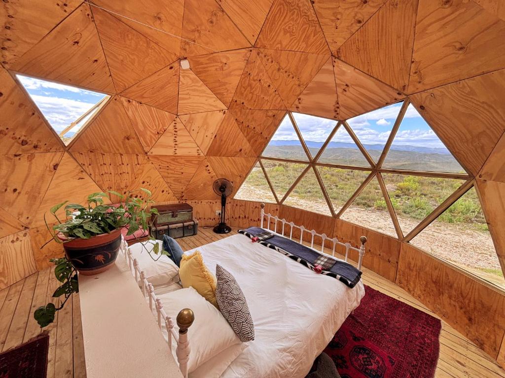 a bed in a wooden room with windows at Starry Starry Night - Route 62 in Montagu