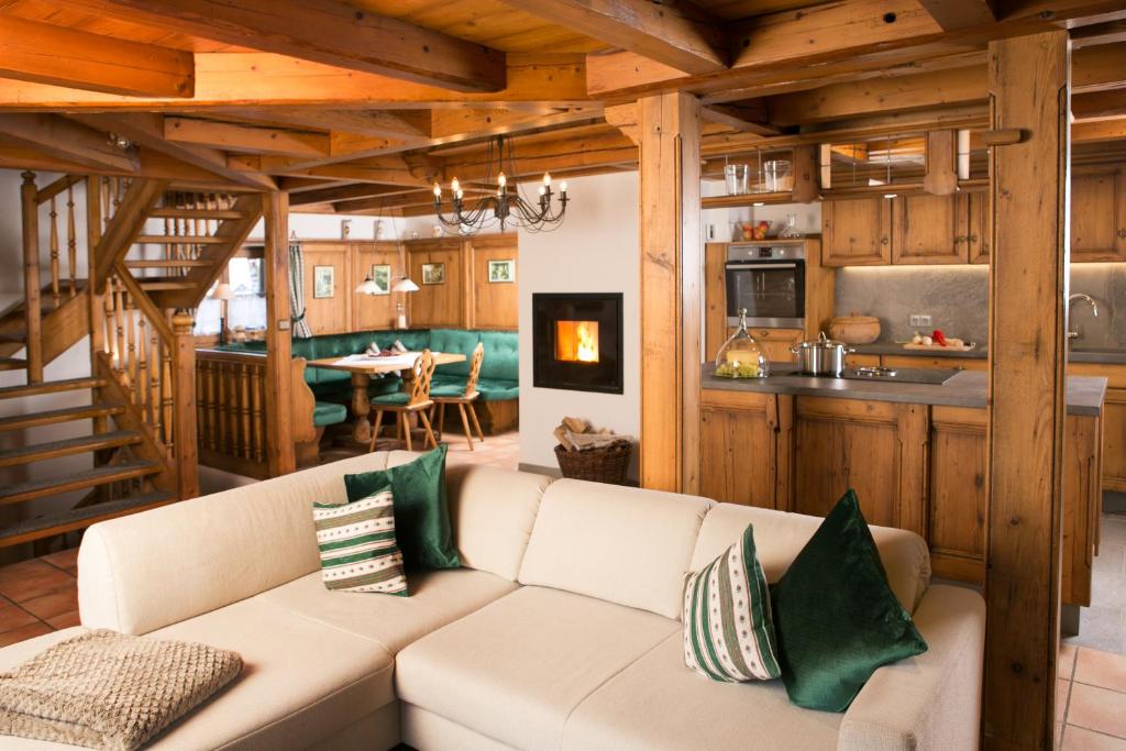 a living room with a couch and a kitchen at Chalet am Frohmarkt in Oberstdorf