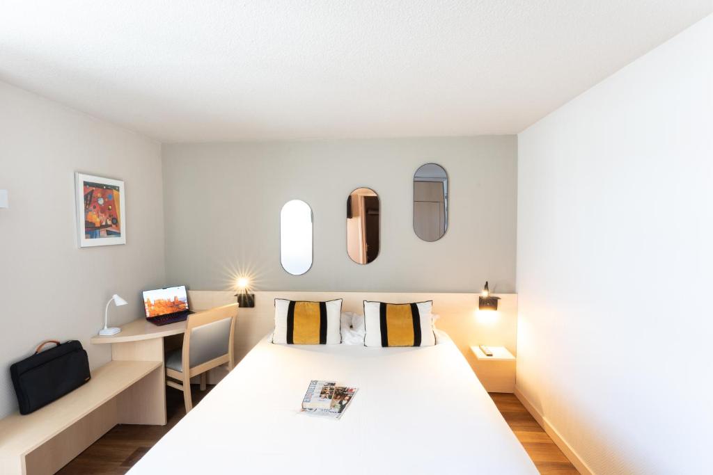a hotel room with a bed and a desk at Le Konine - Hotel & Bar & Restaurant in Montceau-les-Mines