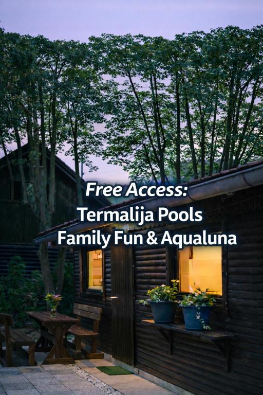 a house with a sign that reads free access tentula pools family fun at Hiška Darwin in Podčetrtek