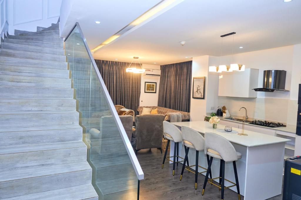a kitchen and a living room with a staircase at Jimi Comfort Stay in Bamgbose