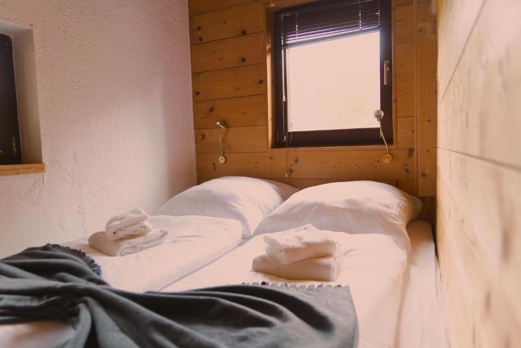 a room with four beds with white sheets and a window at Romantisches Berg-Chalet in Bayrischzell