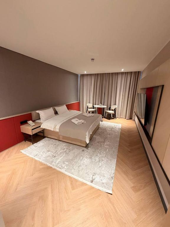 a bedroom with a bed and a table and chairs at AQMYRZA Inn in Zharkent