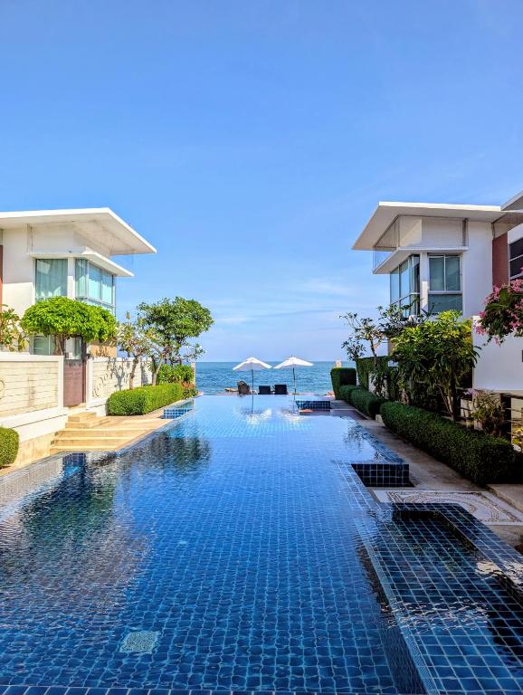 a swimming pool in front of some buildings at Vimanlay 84m style balinais - 2 chambres - plage, piscines in Cha Am