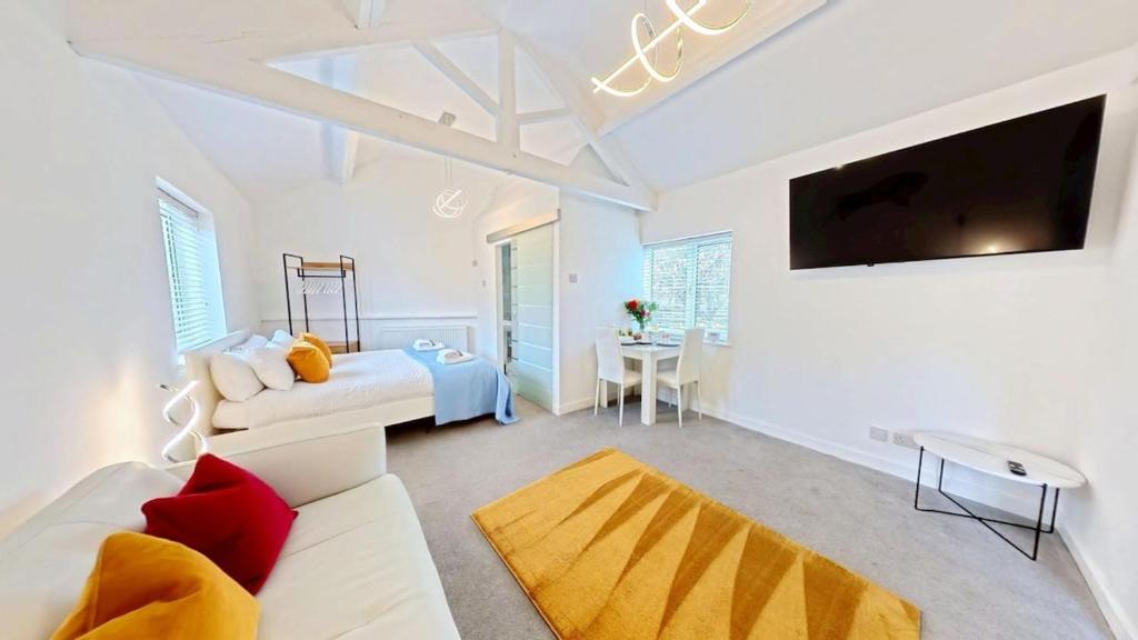 a living room with a white couch and a tv at The Saddlery in Sewerby