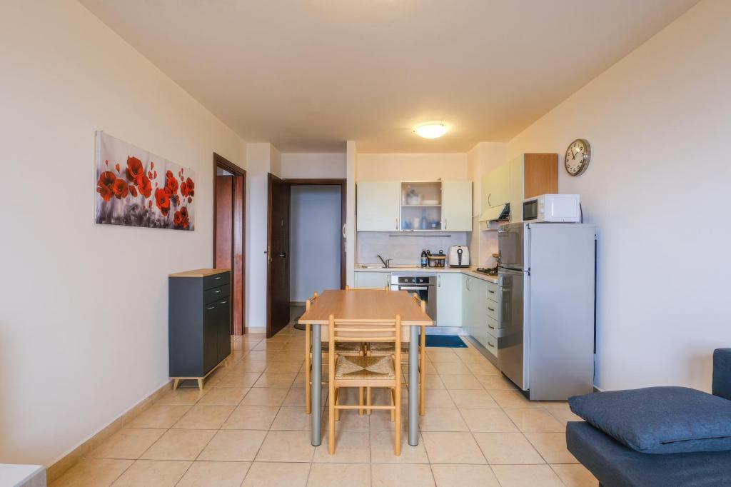 a kitchen and dining room with a table and a refrigerator at Vista Mare in Sassonetto