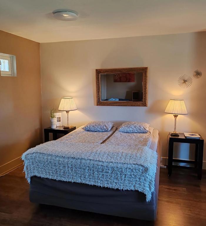 a bedroom with a bed and two lamps and a mirror at Villa Tammikallio Guest House, near the airport - Kodikas vierasmaja Tuusulassa in Tuusula
