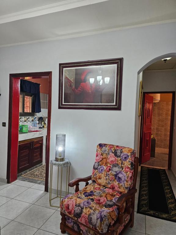 a living room with a chair and a picture on the wall at Mathildah's Appartements in Libreville