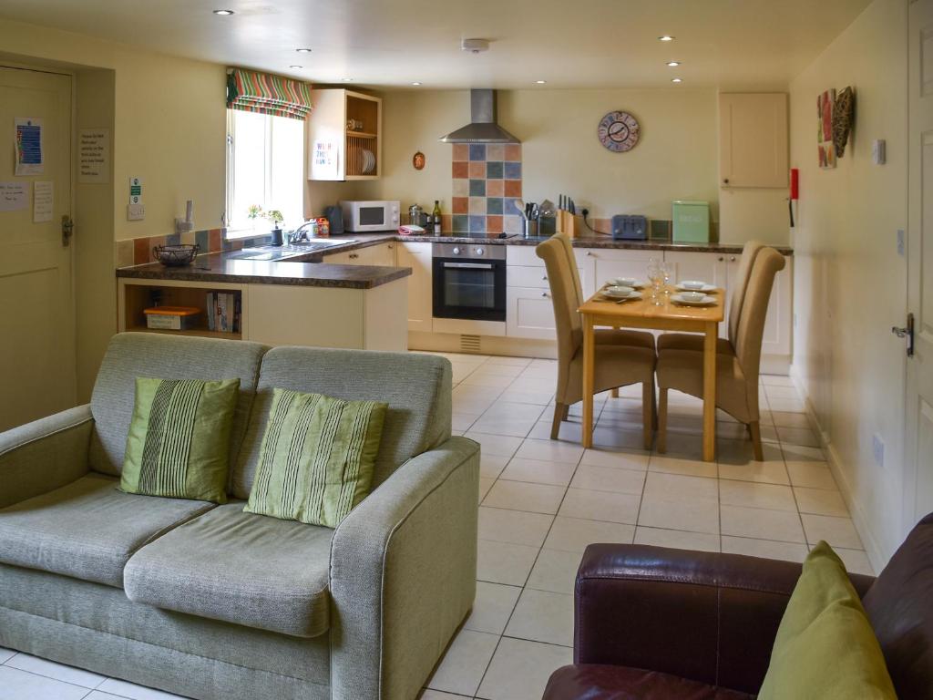 a living room with a couch and a table in a kitchen at Lily Pad 5 - Uk43913 in Nassington
