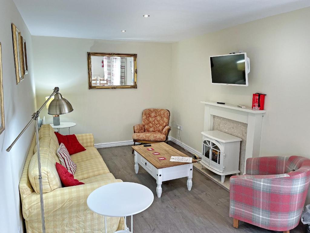a living room with a couch and a fireplace at Willow Cottage - Uk51376 in Winston