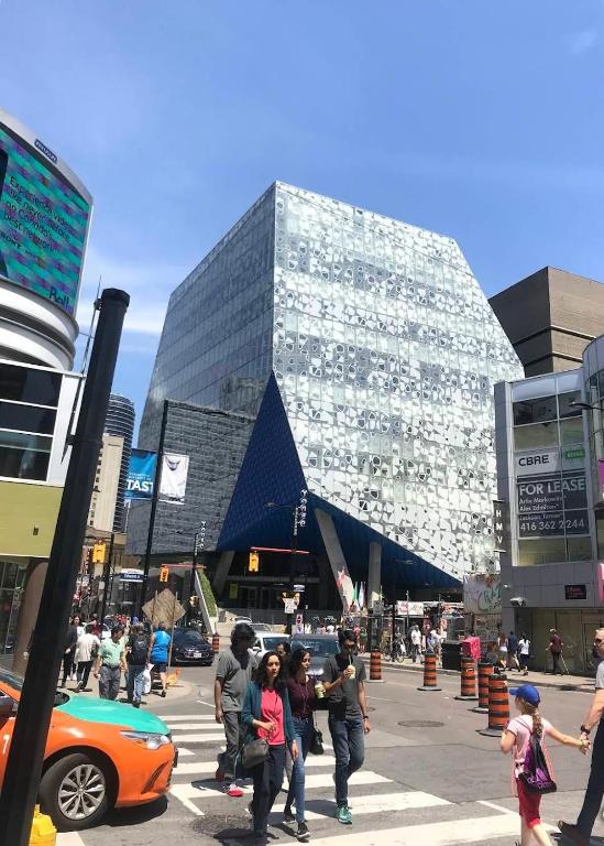 a group of people crossing a street in front of a building at TORONTO UNIVERSITY PRIVATE ROOM-Next to Eaton Centre in Toronto