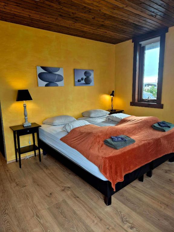a bedroom with a large bed with two pillows at Guestroom with a mountain view in Laugarvatn