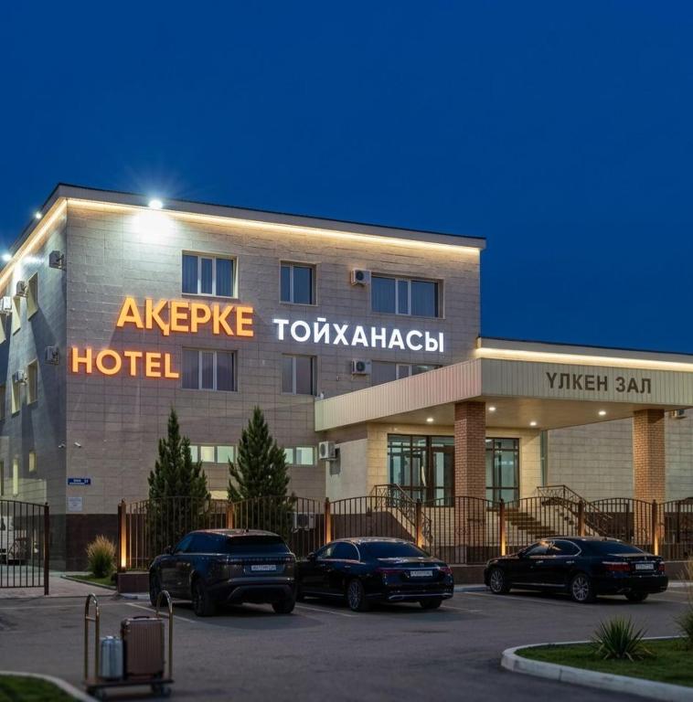 a hotel with cars parked in a parking lot at Акерке Балхаш in Balqash