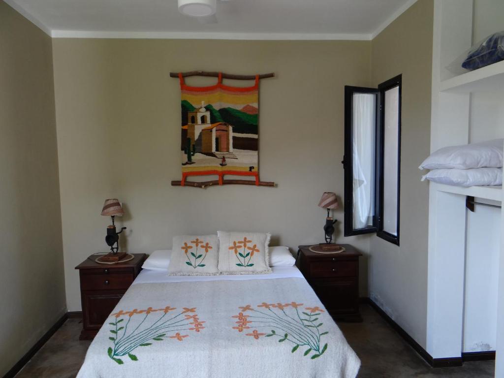 a bedroom with a bed with two night stands and two lamps at Complejo Los Rosales Cafayate in Cafayate