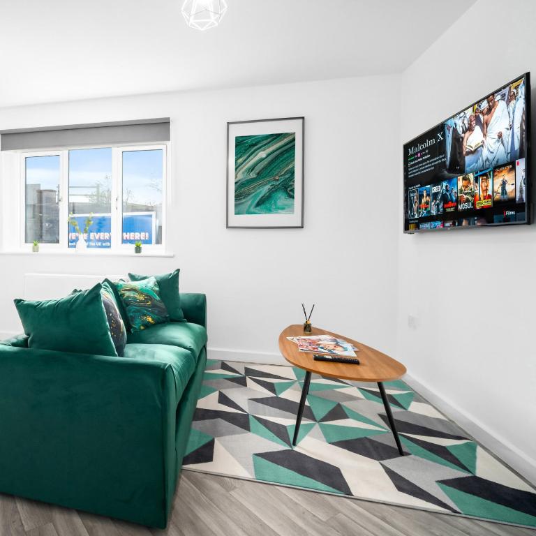 a living room with a green couch and a table at Stylish Two Bed Apartment - Parking - Sleeps 3 - Netflix 55C in Sleightholme