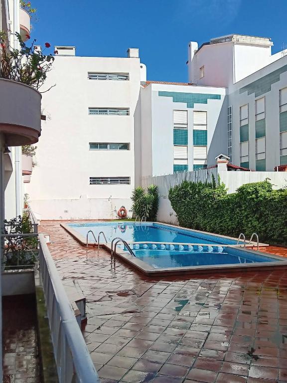 a swimming pool in front of a building at Beach & Pool in Costa da Caparica